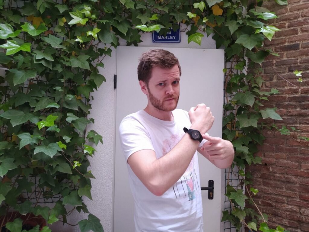 profesor de inglés de nativo señalando su reloj